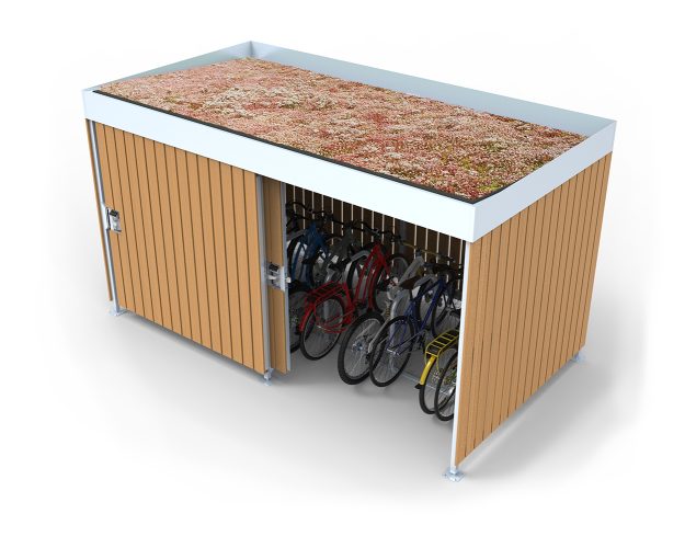 A Cyclehoop bike shelter with a green mesh roof, a wooden finish on the shelter and door, and gate slid half open to show 6 bikes