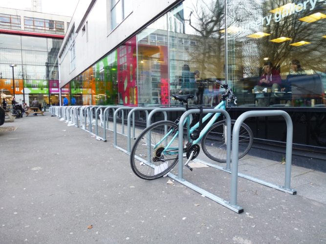 Bike parked within a line of Toast racks outside of a building