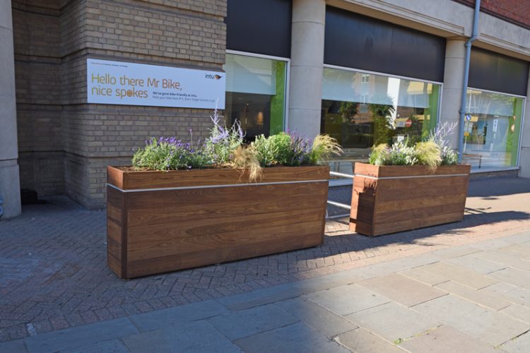 Planter Rack in front of a building. The planters hide the bike racks from view.
