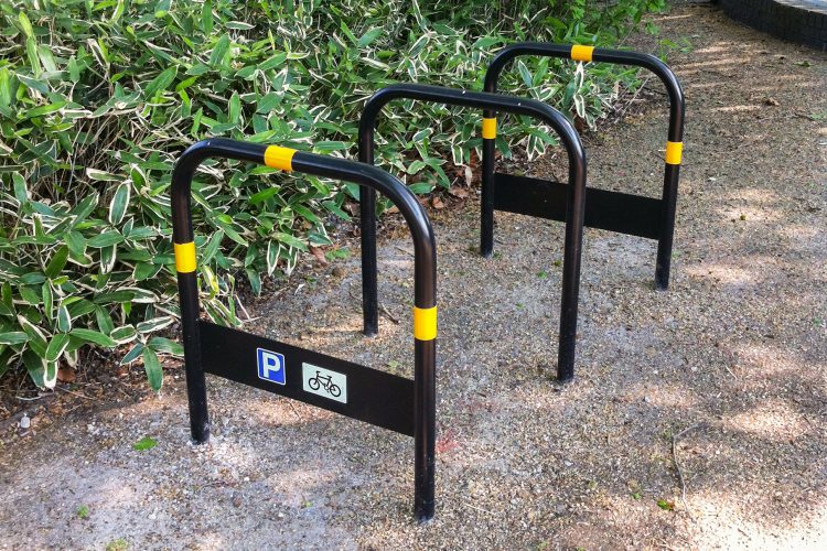 Installation on a gravel surface of three Sheffield Stands with signage for cyclists